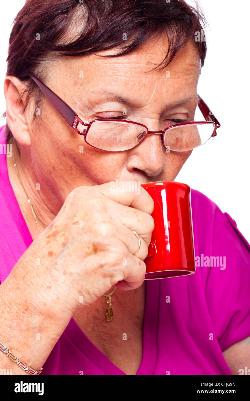 Close up di senior donna bere il caffè espresso, isolati su sfondo bianco. Foto Stock