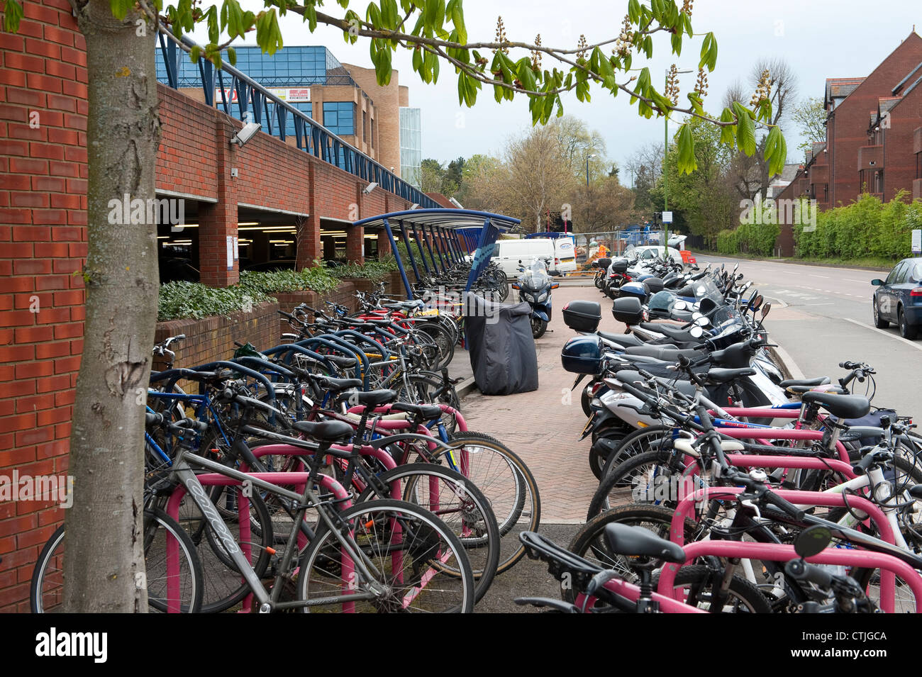 Motociclette e biciclette parcheggiate in modo sicuro in una area di parcheggio al di fuori di una stazione ferroviaria in Inghilterra. Foto Stock