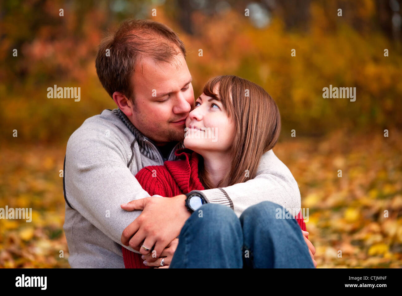 I giovani coniugi abbracciando intimamente in un parco in autunno; Edmonton Alberta Canada Foto Stock