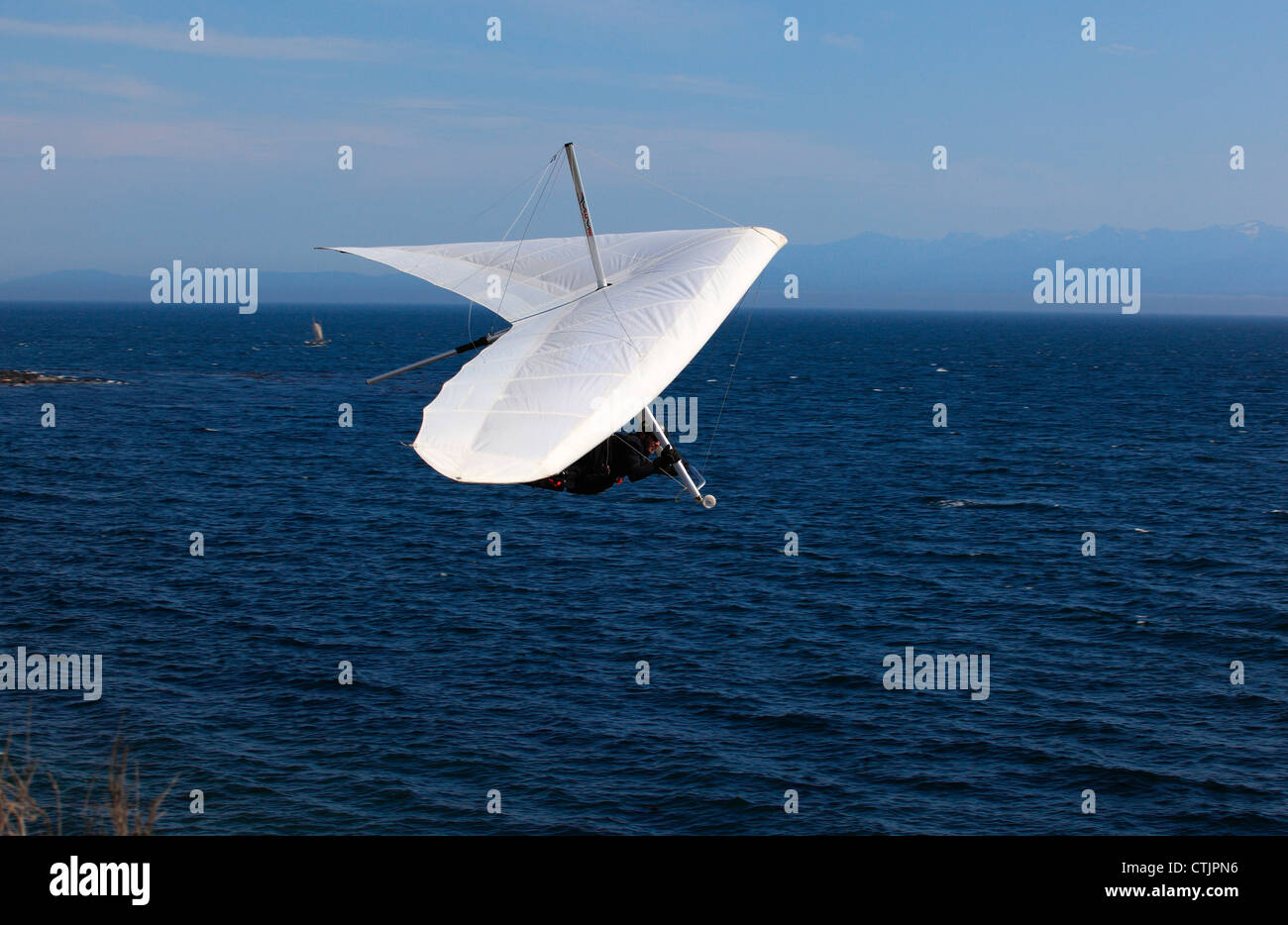 Deltaplano sull'oceano pacifico. Montagne Olimpiche in background Foto Stock