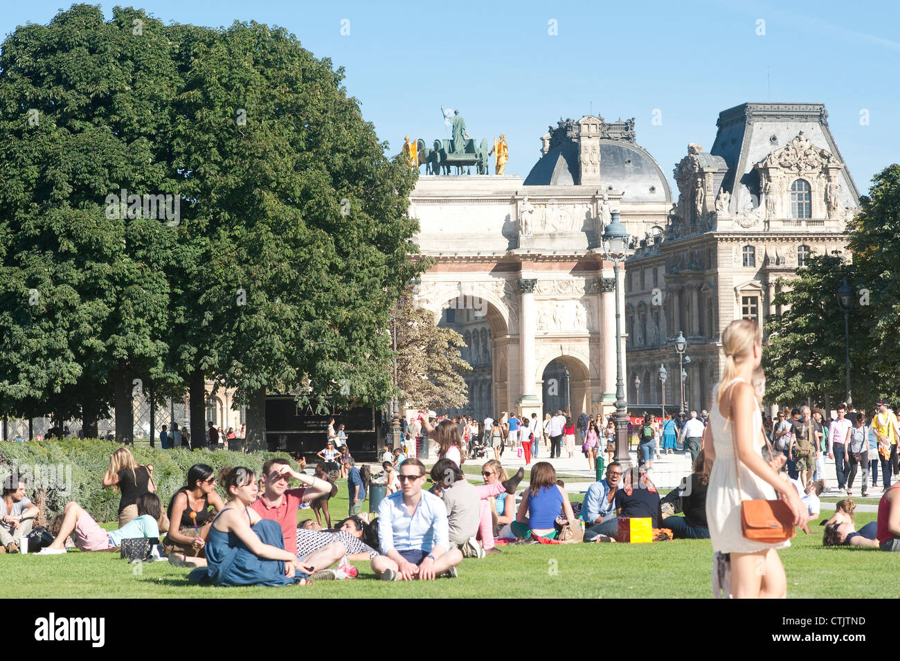 Parigi, Francia - Le persone che si godono una giornata di sole in giardino intorno al Louvre e Arc de triomphe du Carrousel Foto Stock