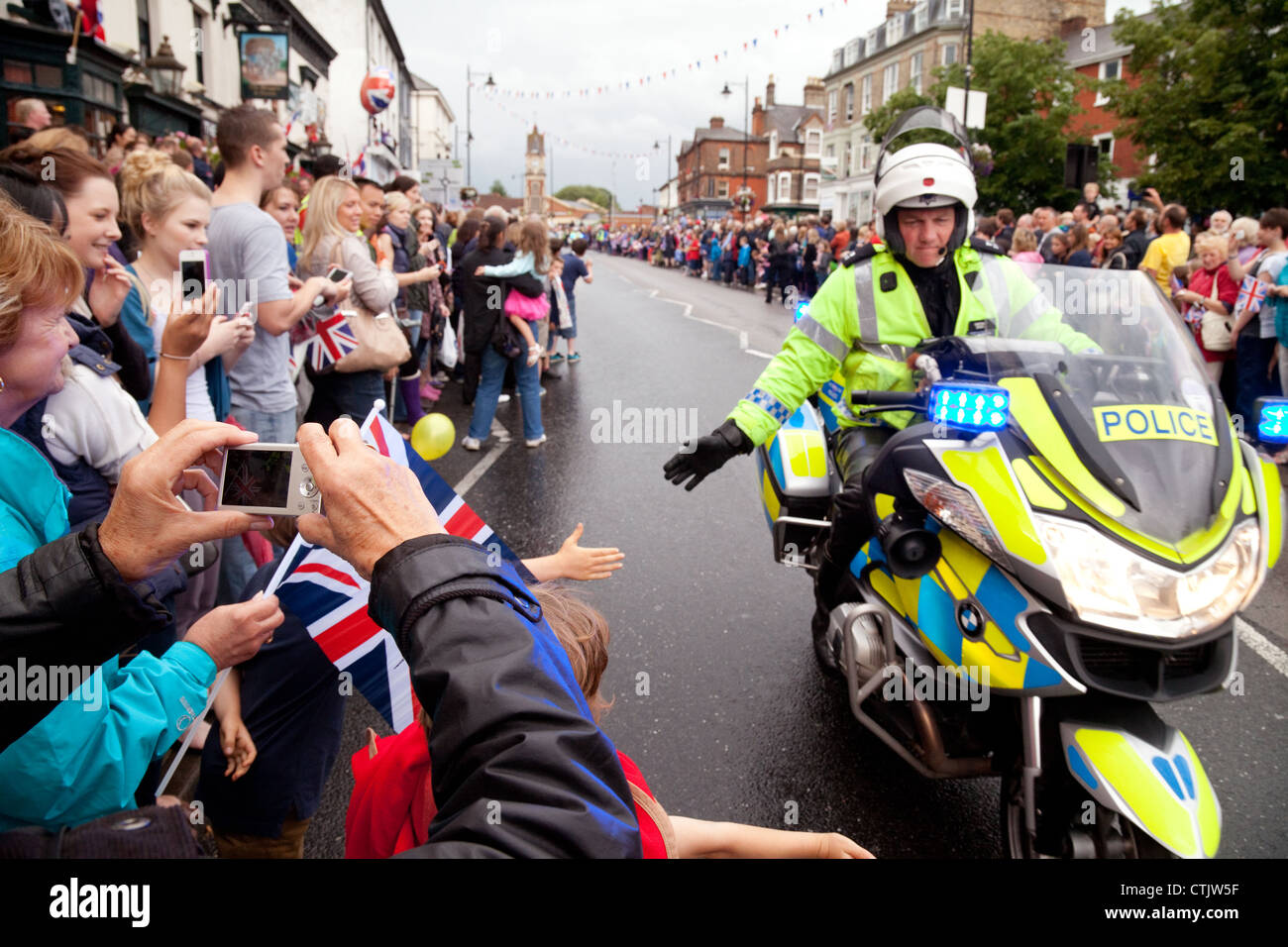 Polizia moto patrol dare ai bambini un alto cinque; 2012 torcia olimpica, Newmarket Suffolk REGNO UNITO Foto Stock