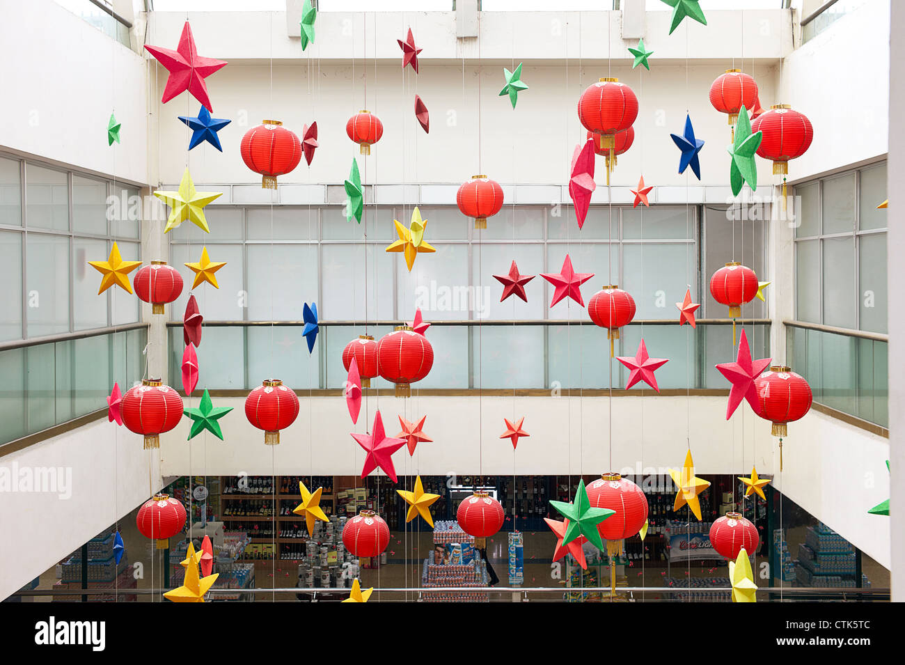 Festive a forma di stella e cinese tradizionale lanterne appese in un centro commerciale per lo shopping Foto Stock Festive a forma di stella e cinese tradizionale lanterne appese in un centro commerciale per lo shopping Foto Stock