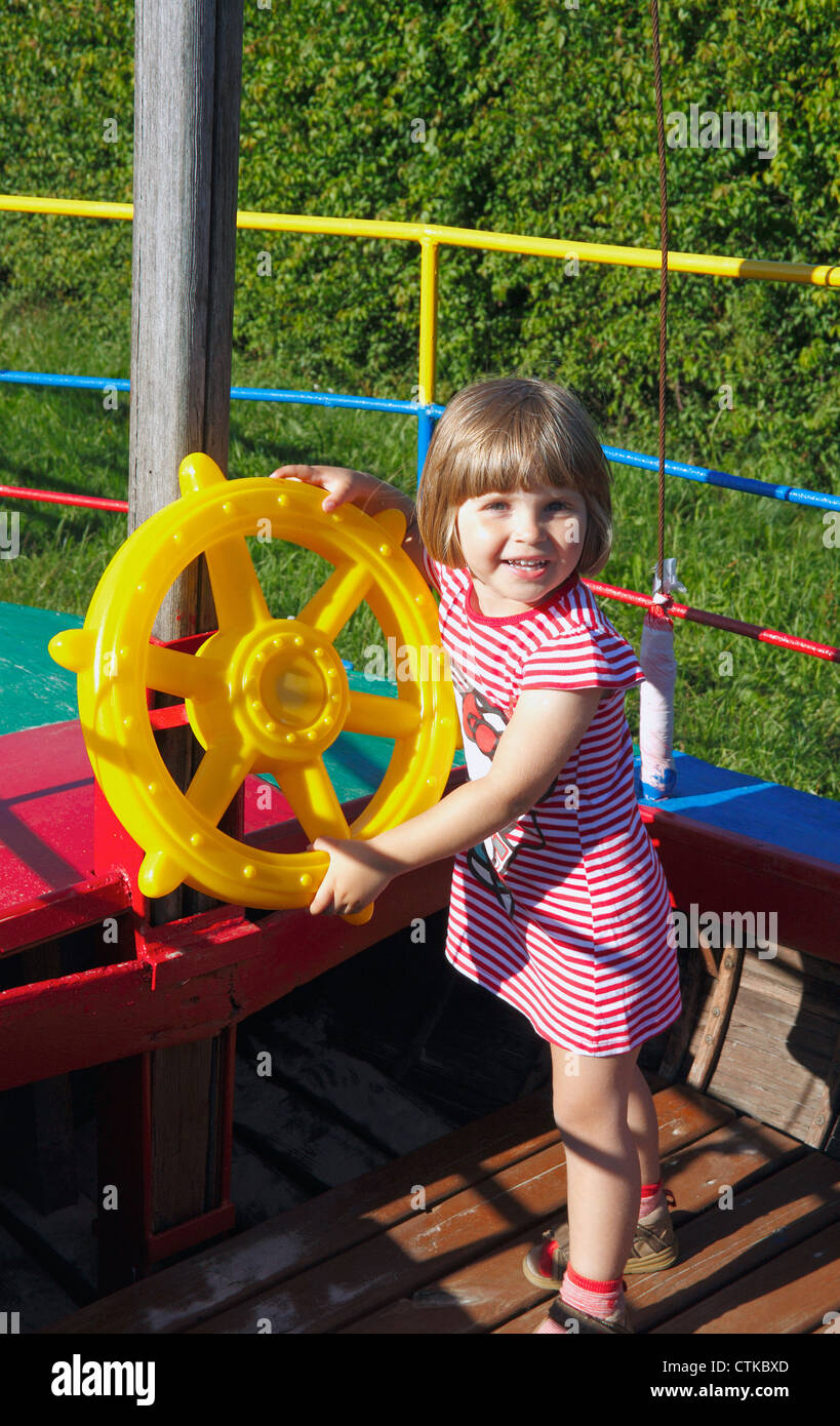 Ragazza capitano dietro il giocattolo delle ruote sterzanti Foto Stock
