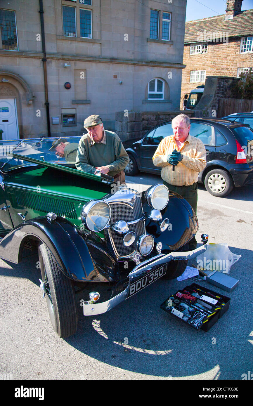 Due uomini di tentare di riparare un'annata Riley 15 Drophead Coupe in Hathersage Parco Nazionale di Peak District Derbyshire England Regno Unito Foto Stock