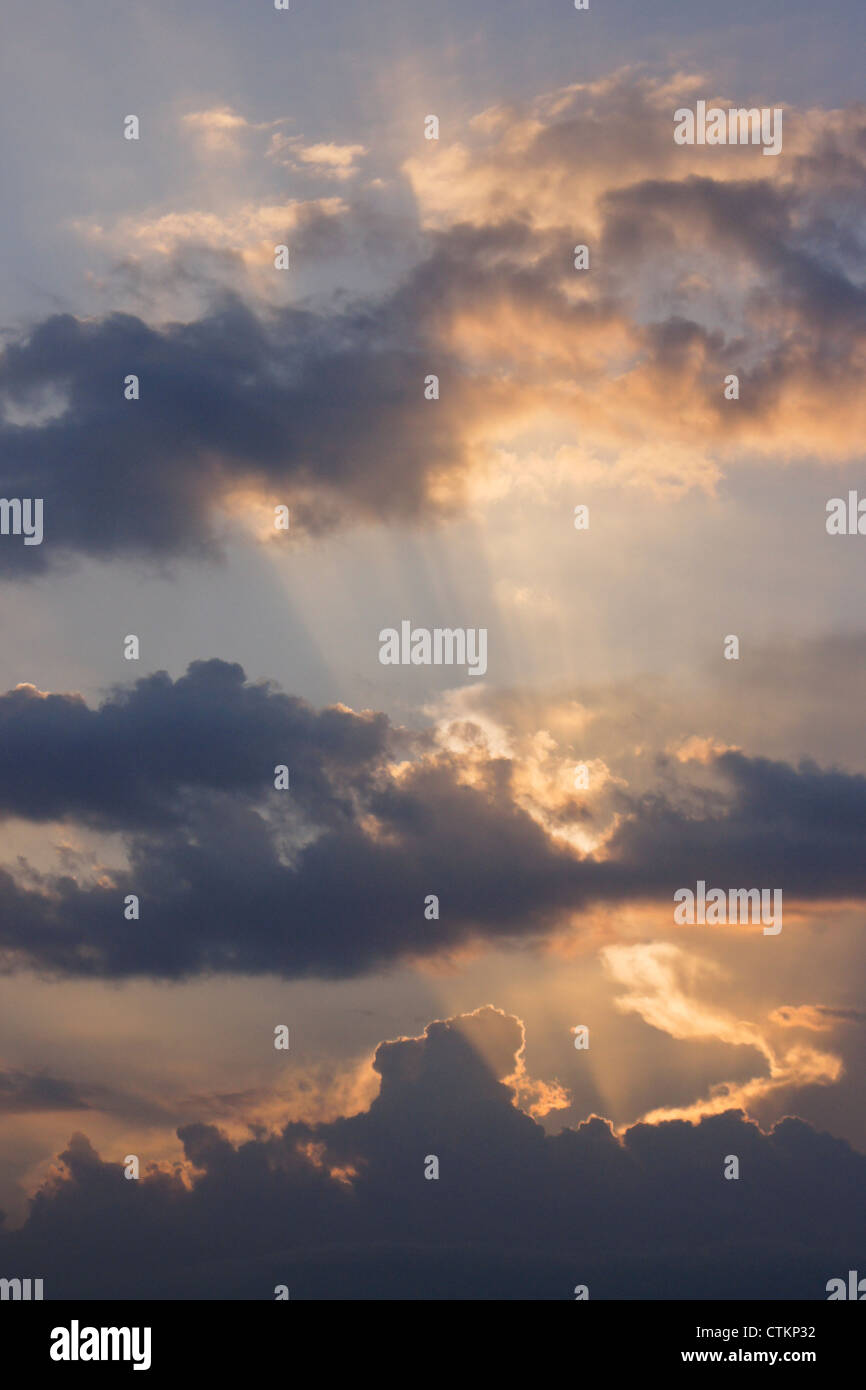 Sun dietro le nuvole (raggi crepuscolari) Foto Stock