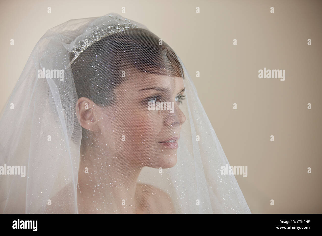 Una giovane sposa che indossa un diadema e velo con uno strappo che corre lungo il suo volto Foto Stock