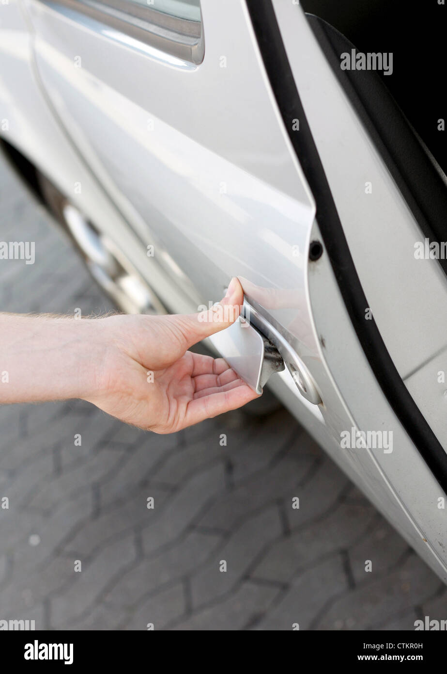 Una mano di aprire la portiera della macchina Foto Stock