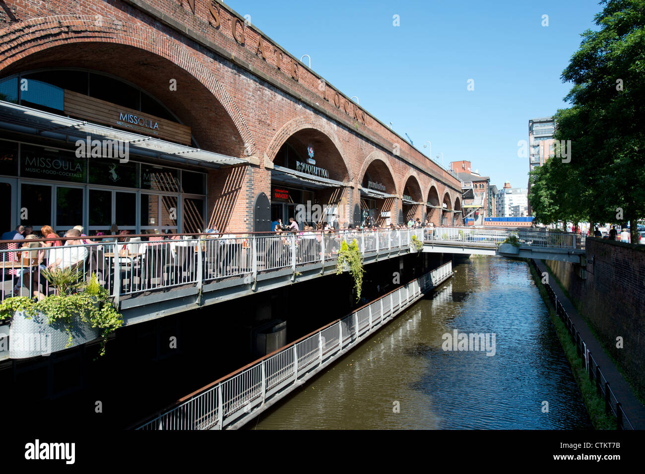 Le persone godono di socializzare con un drink al sole estivo a Deansgate Locks in Manchester. Foto Stock