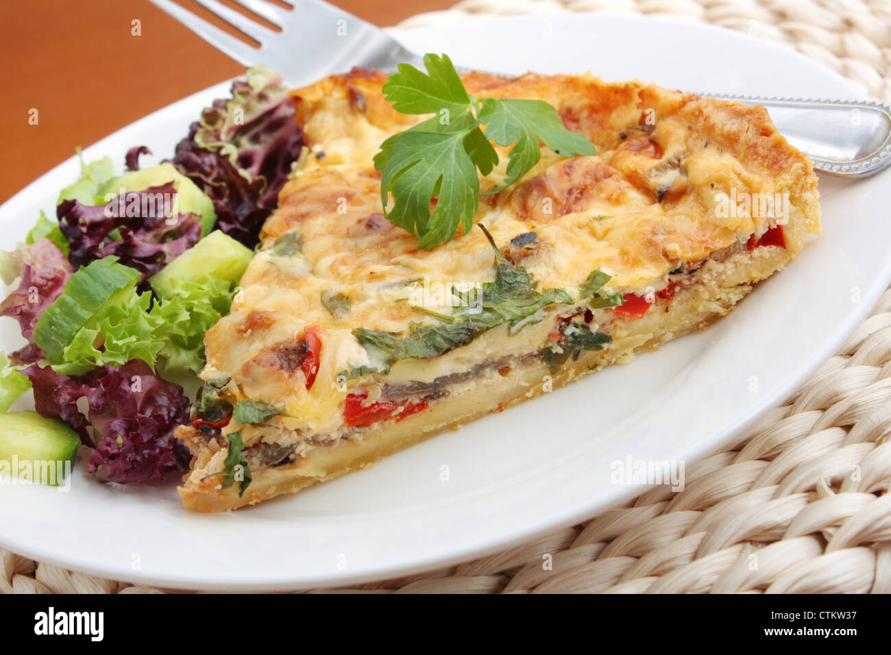 Una fetta di Caponatina siciliana comprese le cipolle e peperoni rossi e funghi con una semplice insalata di contorno. Foto Stock