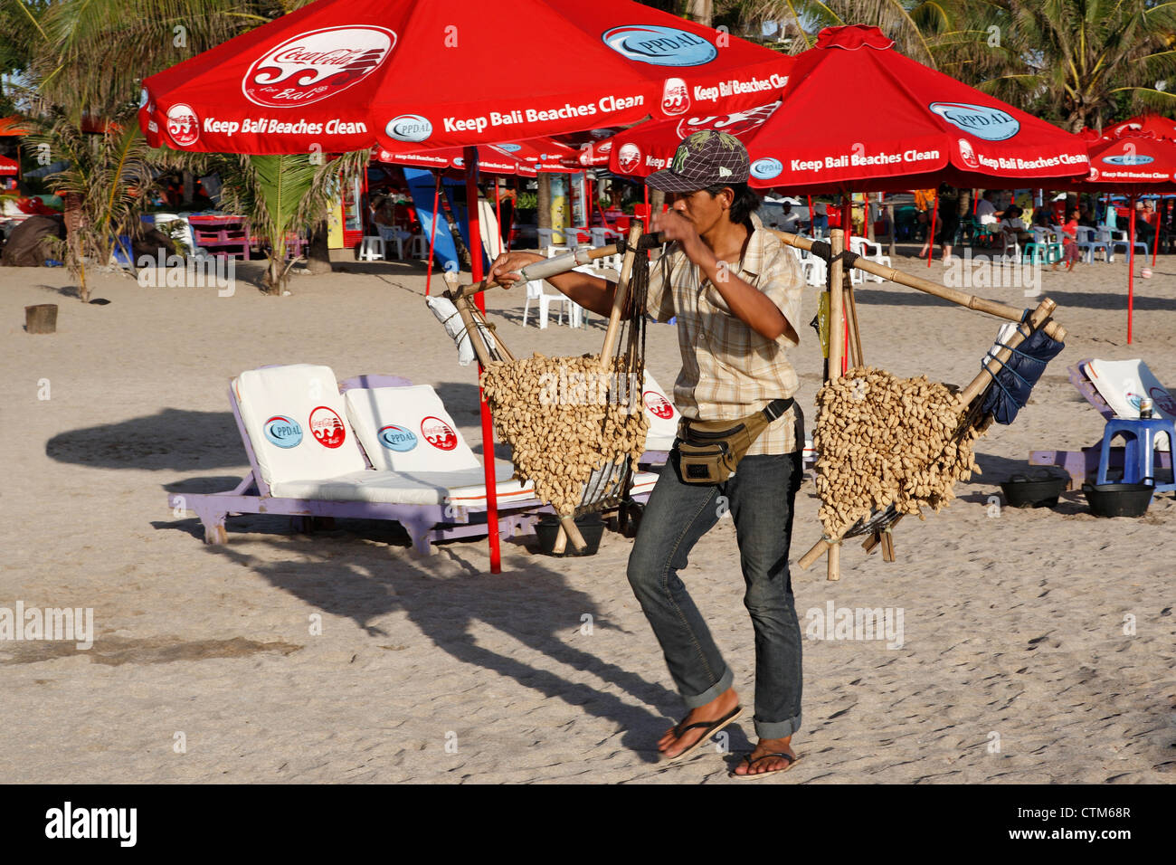Uomo Balinese vendita di arachidi in Kuta Legian Beach. Bali, Indonesia Foto Stock