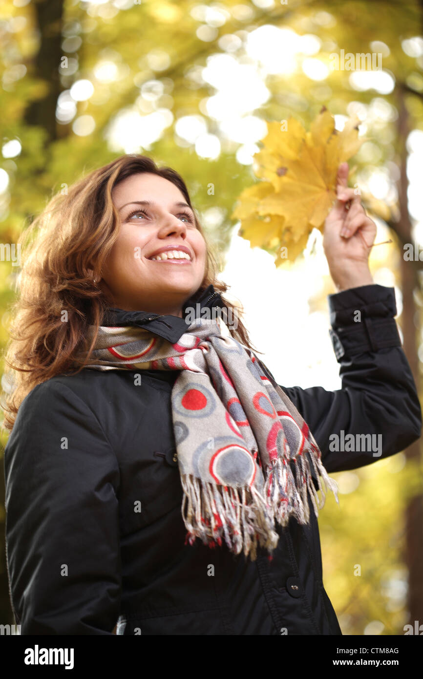 Giovane donna sorridente nel parco d'autunno. Foto Stock