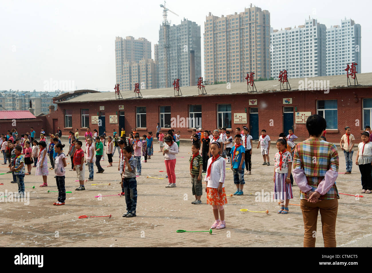 Gli studenti non la radio di esercizi ginnici in una scuola primaria per i figli dei lavoratori migranti ad Harbin, Heilongjiang, Cina. 2012 Foto Stock