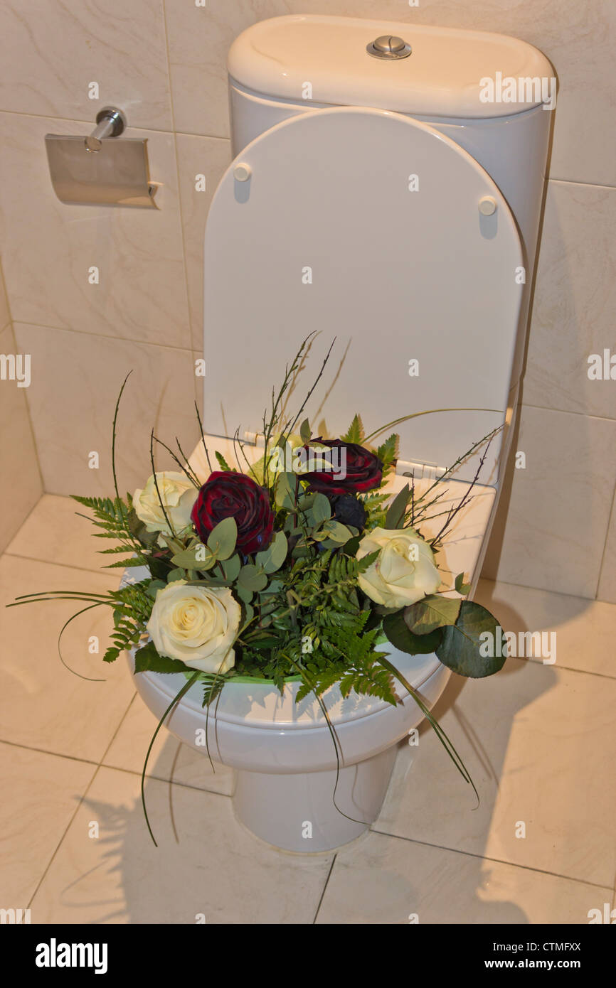Boquet di fiori gettati nella tazza di gabinetto. Foto Stock
