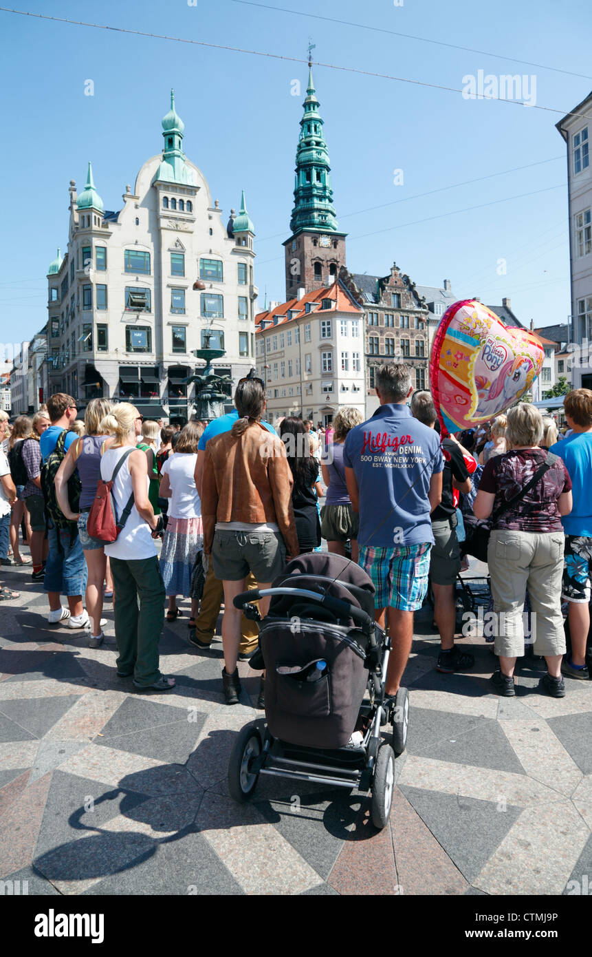 La folla di gente a guardare gli artisti di strada a Amagertorv per lo shopping, il divertimento e la via pedonale Strøget a Copenaghen. Foto Stock