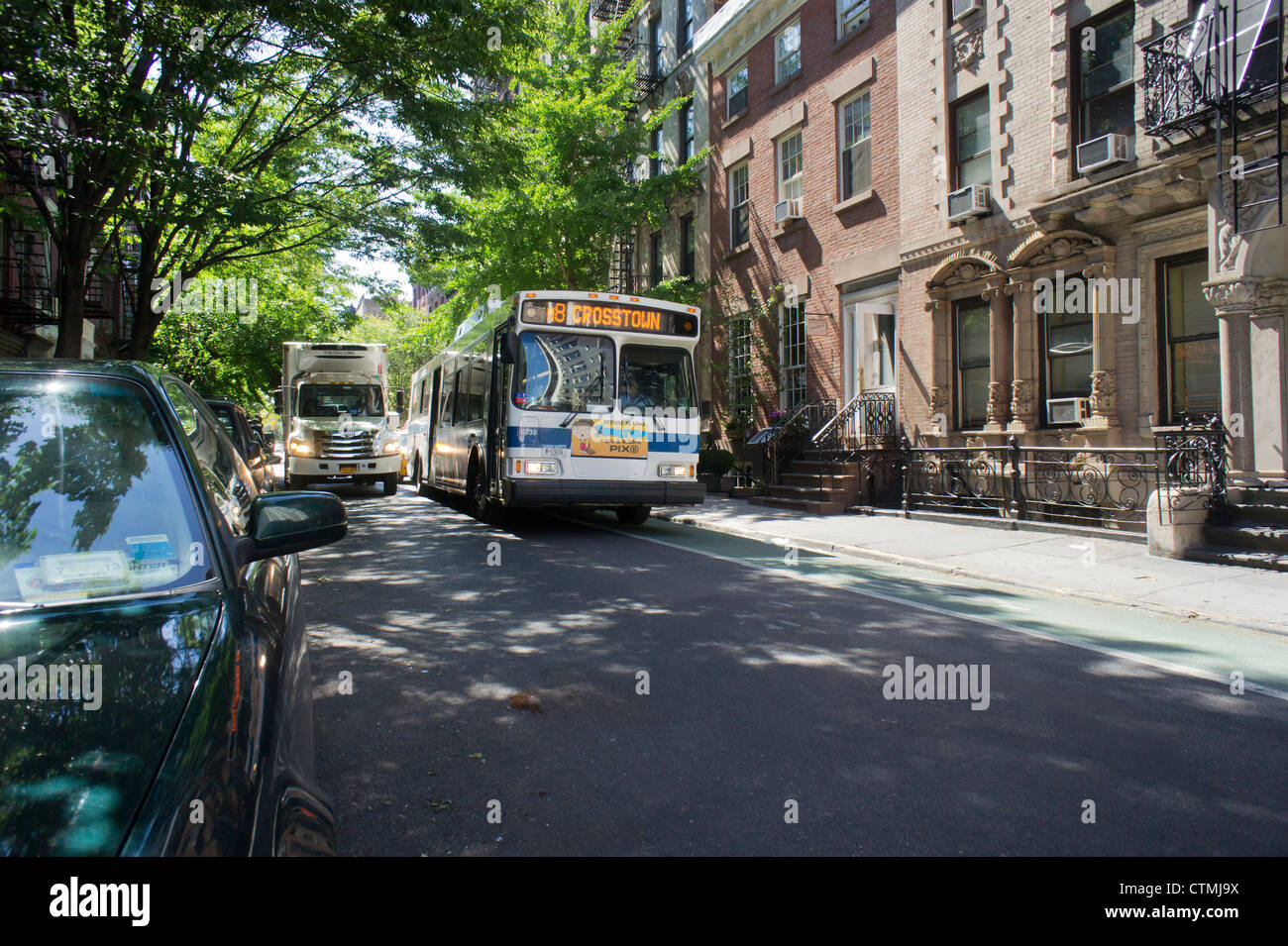 Un NYC Transit Bus manovre attraverso le strette strade del Greenwich Village quartiere di New York Foto Stock