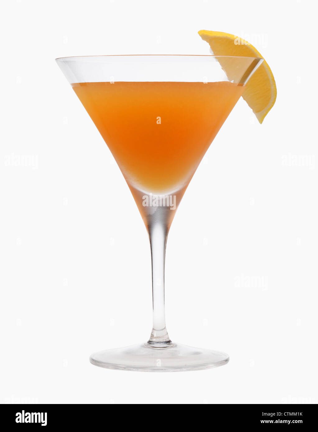 Un cocktail di gambi di vetro con un liquido arancio e limone guarnire su uno sfondo bianco. Foto Stock