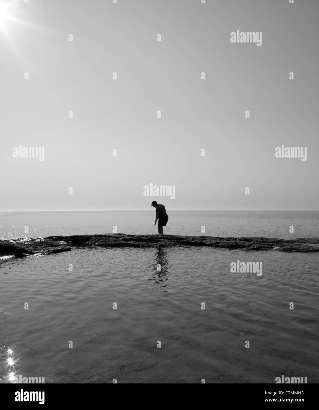 Una donna si stagliano nel sole del mattino sul lago Michigan in Door County, Wisconsin. Foto Stock