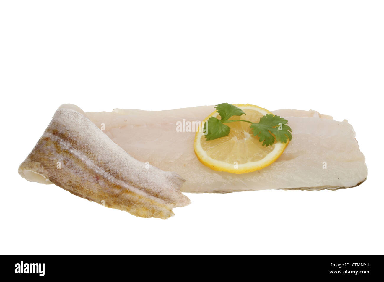 Crudo fresco filetto di merluzzo con una fettina di limone e prezzemolo e guarnire isolata contro bianco Foto Stock