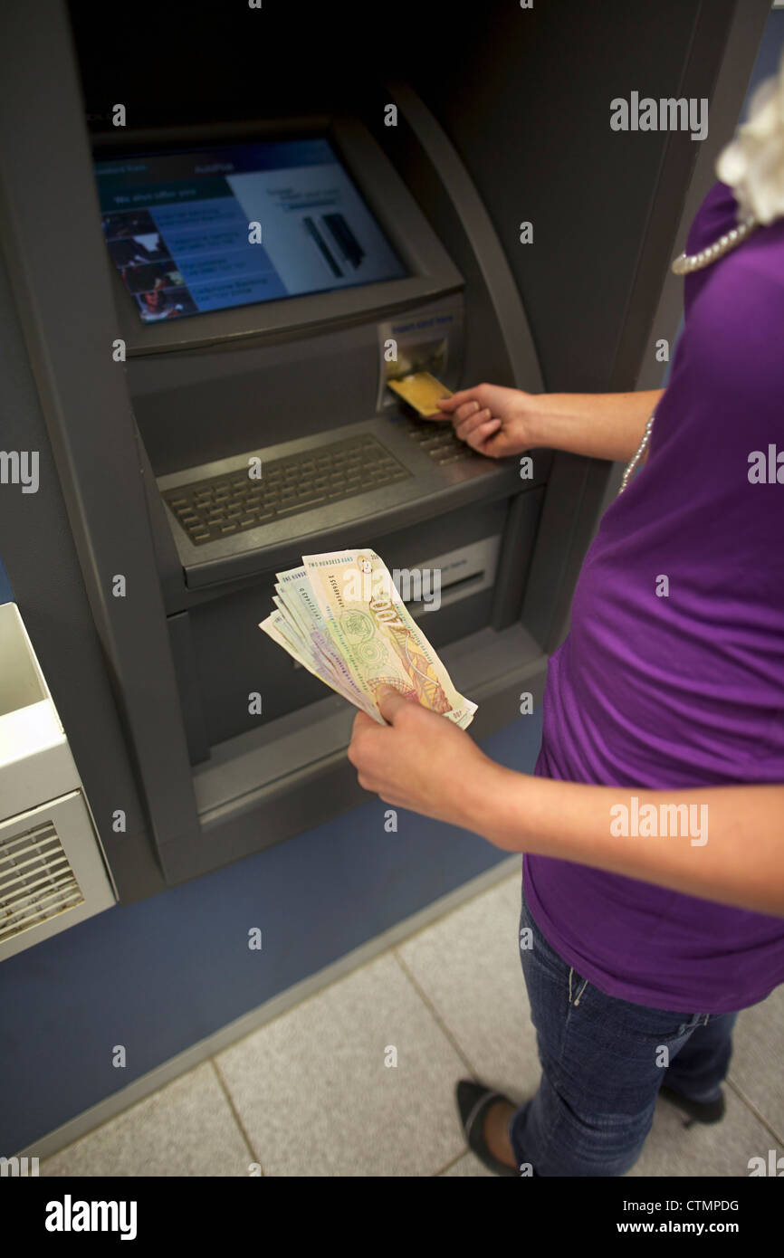 Una giovane donna disegno denaro da ATM, Pietermaritzburg, KwaZulu-Natal, Sud Africa Foto Stock