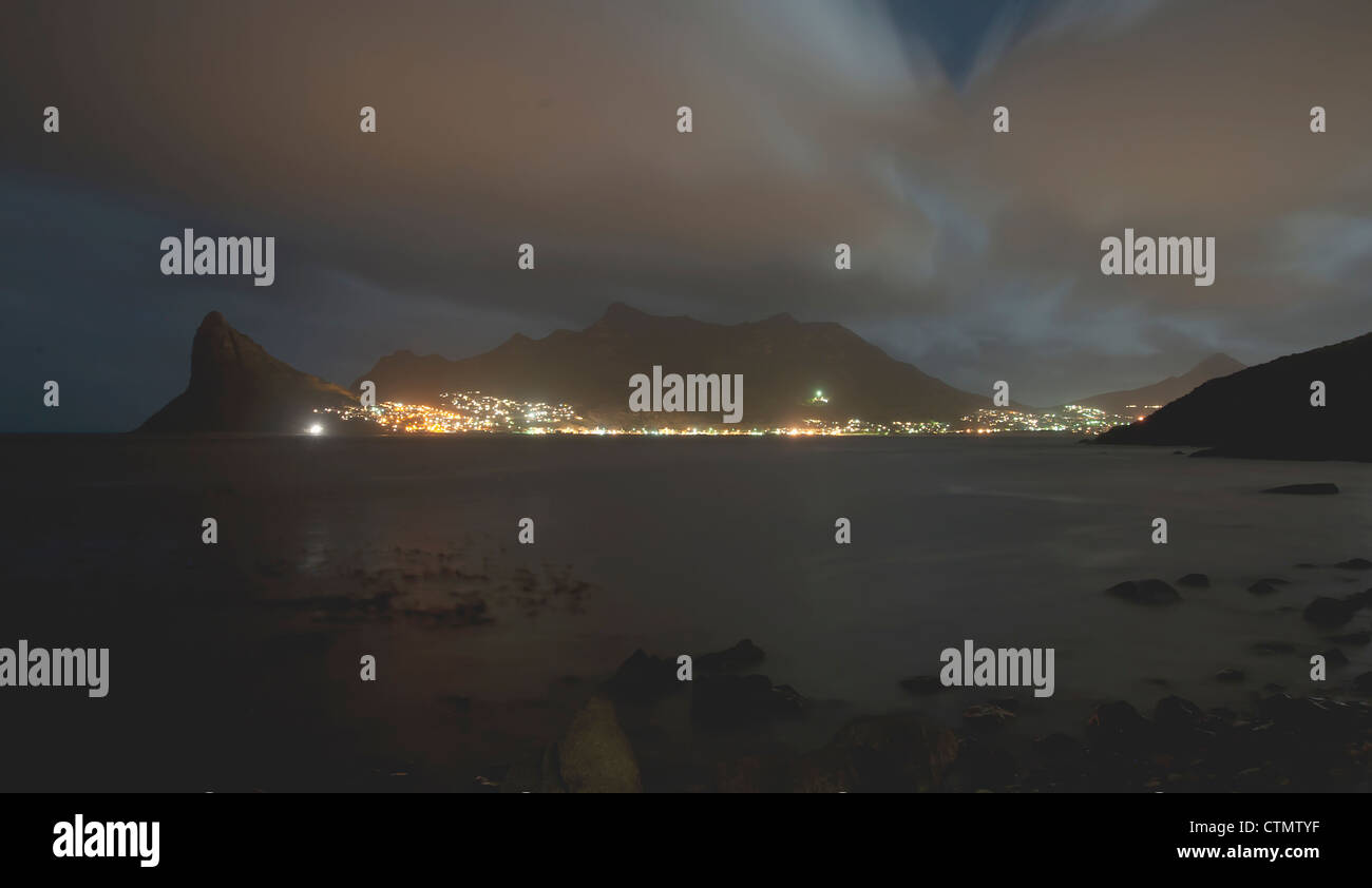 Hout Bay Harbor e Sentinel visto da Tintswalo Atlantic lodge di notte, Cape Town, Sud Africa Foto Stock