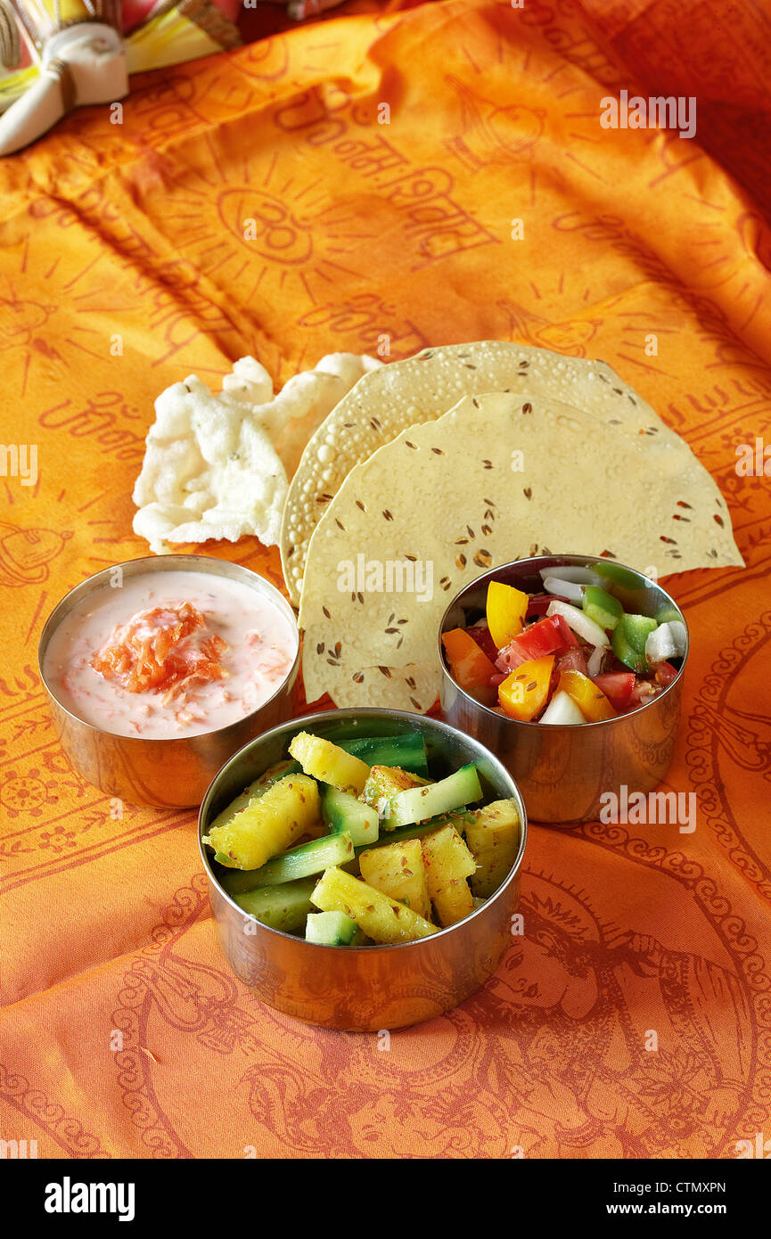 Cucina indiana. La carota raita, cetriolo relish, pomodoro fresco e insalata di cipolla / kachoomer con paapri e pappadums Foto Stock