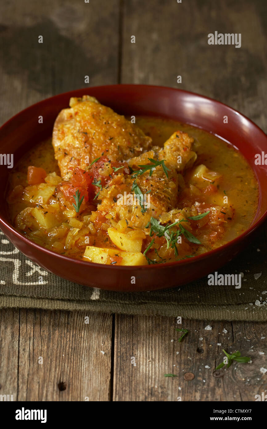 Tradizionale cucina africana. Speziato malawiana pollo al curry. Ingredienti - pezzi di pollo, peperoncino, patate, pomodori e cipolle Foto Stock