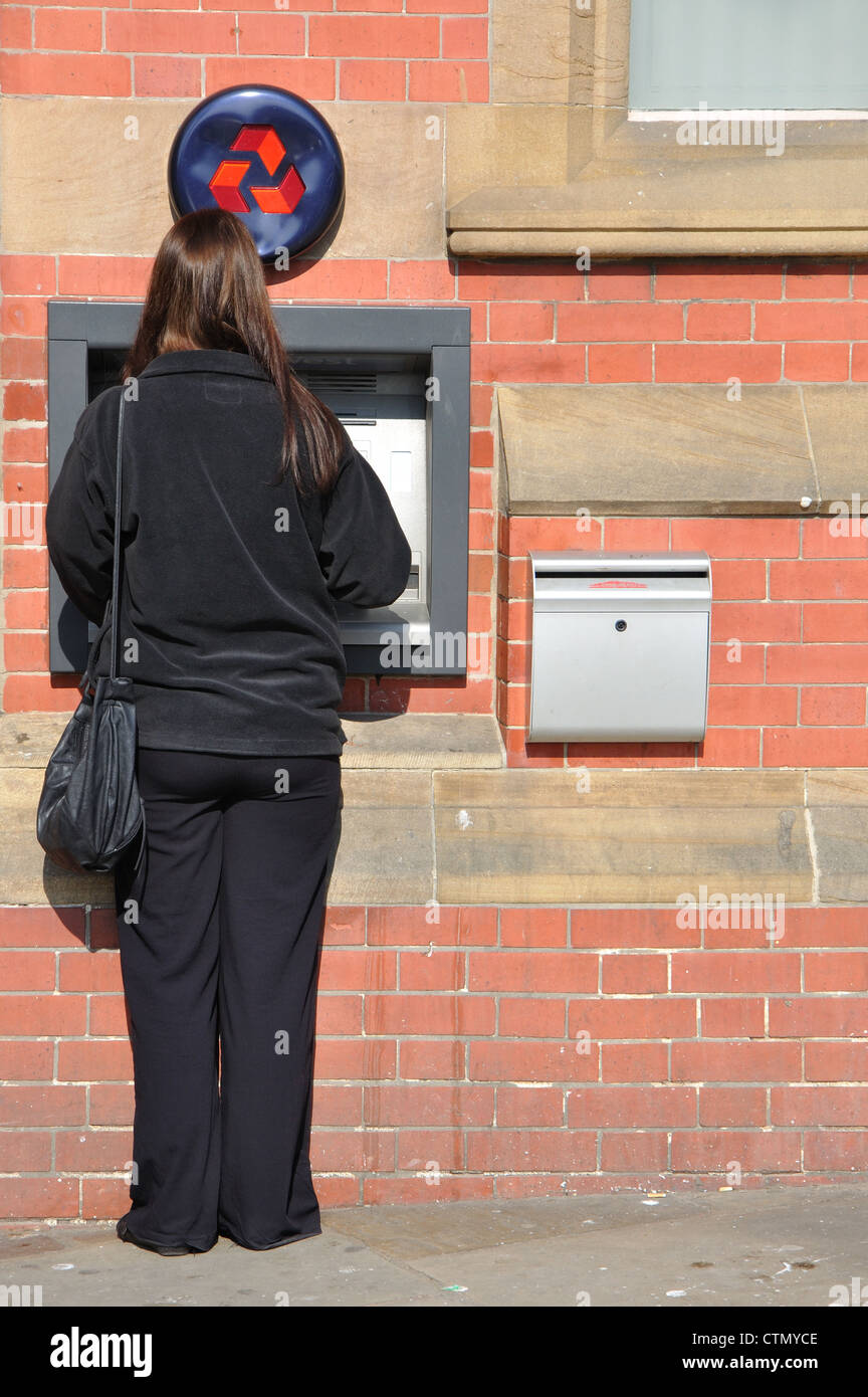Donna che utilizza ATM, Natwest, Whitby, North Yorkshire, Inghilterra, Regno Unito Foto Stock