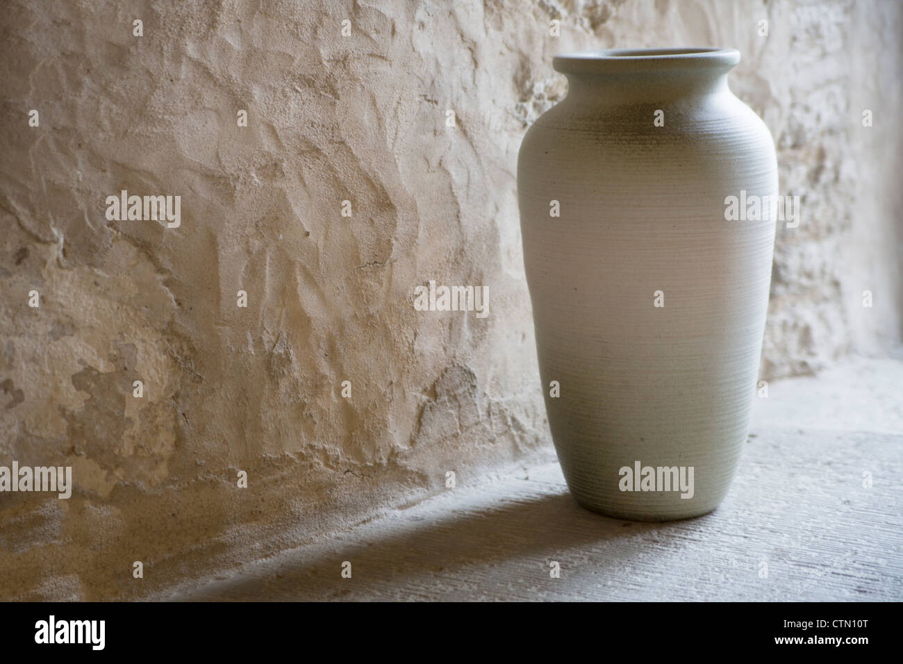 Fatto a mano e levigato vaso in angolo di camera Foto Stock