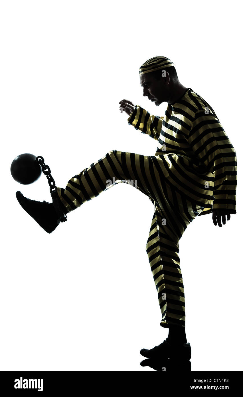 Un uomo caucasico prigioniero criminale che giocano a calcio con catena pallina in studio isolato su sfondo bianco Foto Stock
