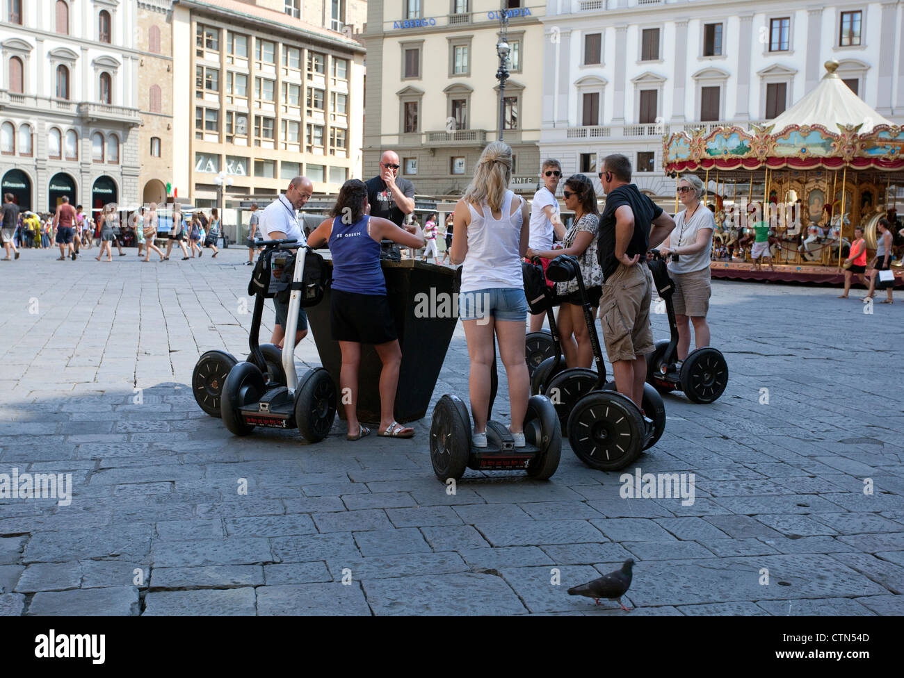 Gruppo di turisti su macchine Segway ascoltare la loro guida in Piazza Reppublica, Firenze, Italia Foto Stock