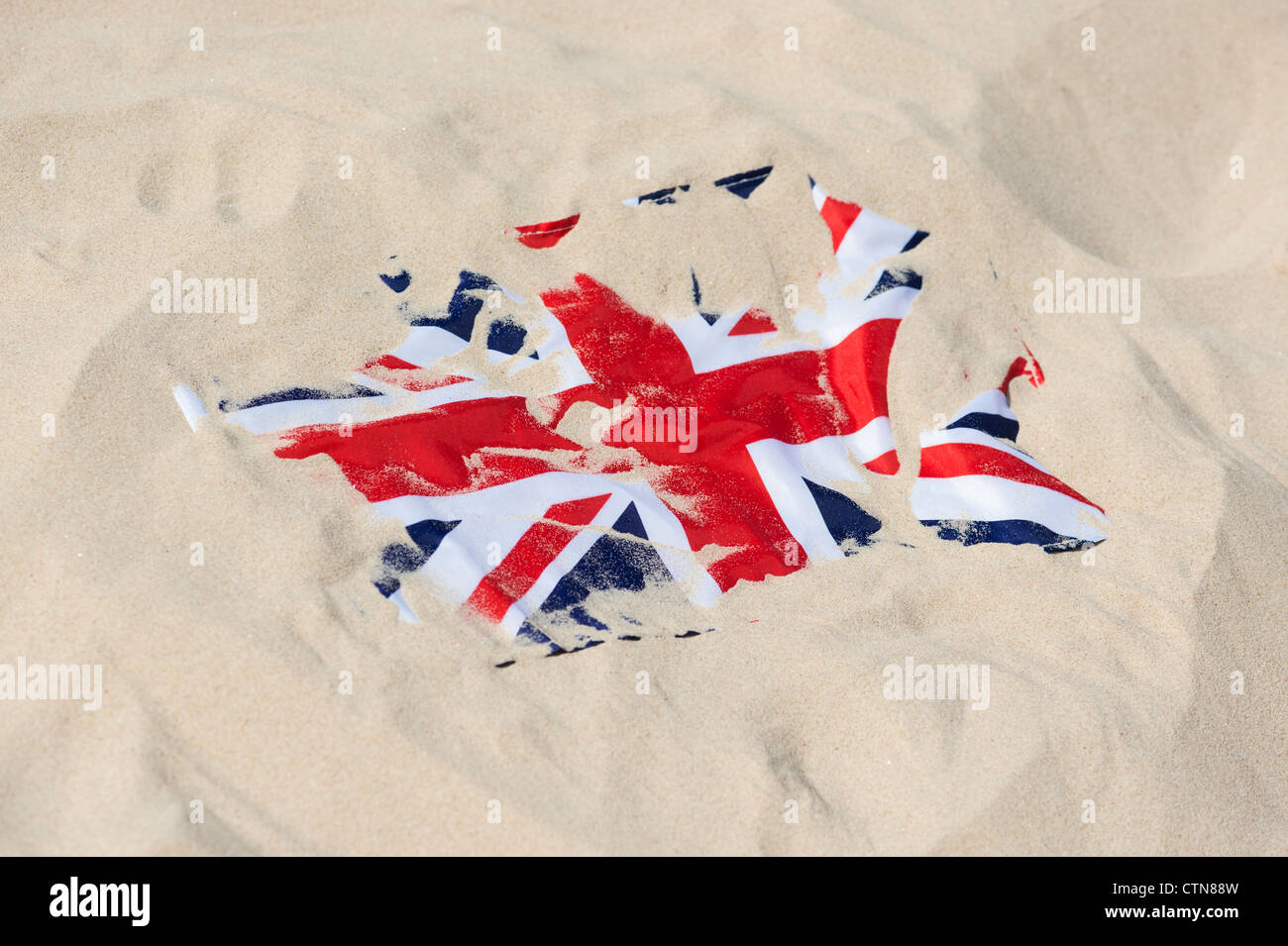 Union Jack flag coperto di sabbia sulla spiaggia Foto Stock