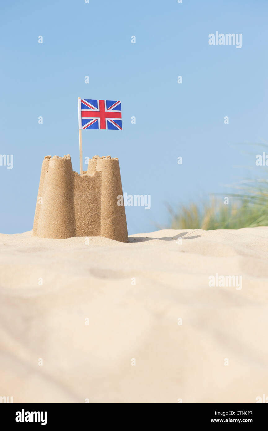Union Jack flag in un castello di sabbia sulle dune di sabbia. Pozzetti accanto al mare. Norfolk, Inghilterra Foto Stock