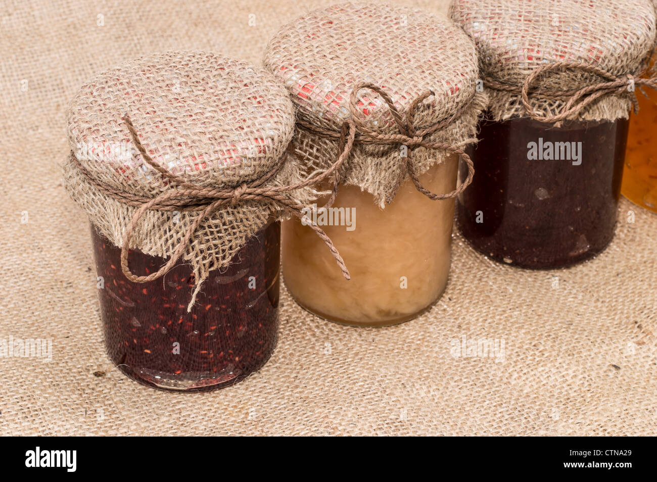 Fresche marmellata fatta in vasi su sfondo rustico Foto Stock