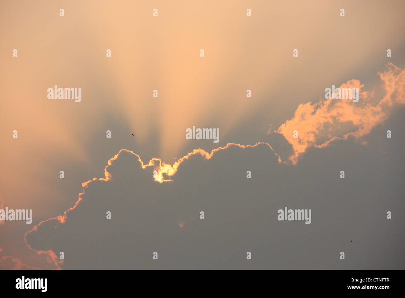 Raggi crepuscolari dietro il cloud al tramonto Foto Stock