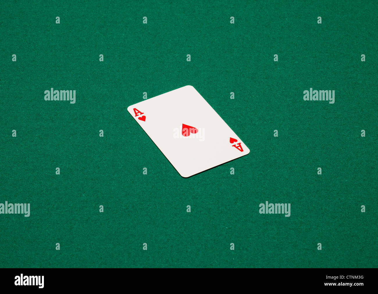 Carta da gioco su un tavolo verde. L'asso di cuori Foto Stock