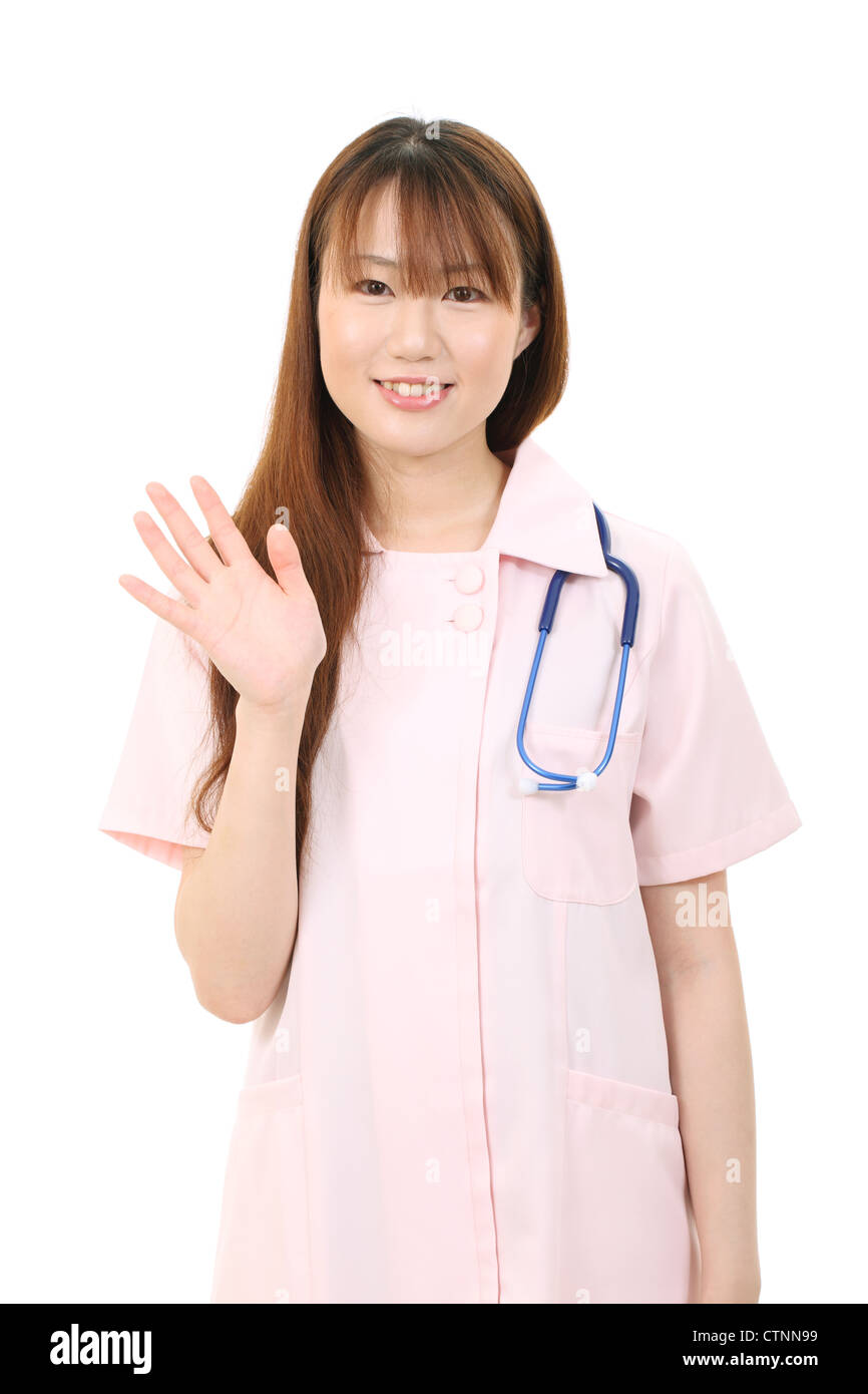 Giovani asiatici infermiera femmina agitando la mano Foto Stock