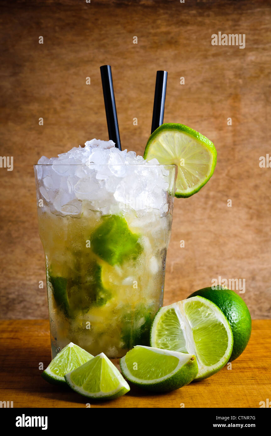 Caipirinha cocktail drink con limes su uno sfondo di legno Foto Stock