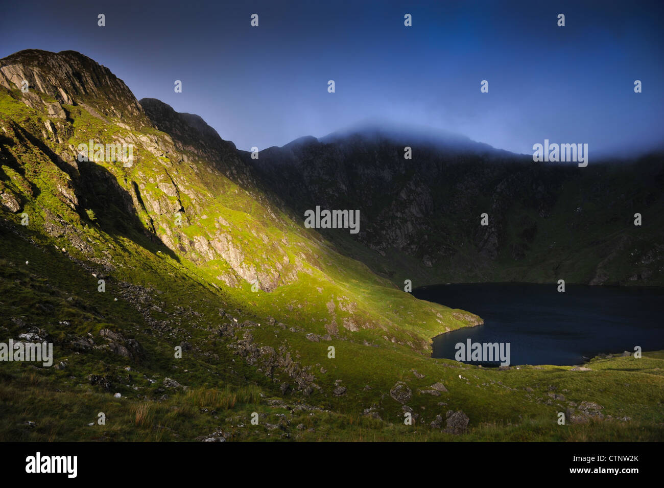La mattina presto la luce del sole con vista di Craig Cau e Llyn Cau. Preso dal percorso di Minffordd, Cadair Idris, Snowdonia. Foto Stock