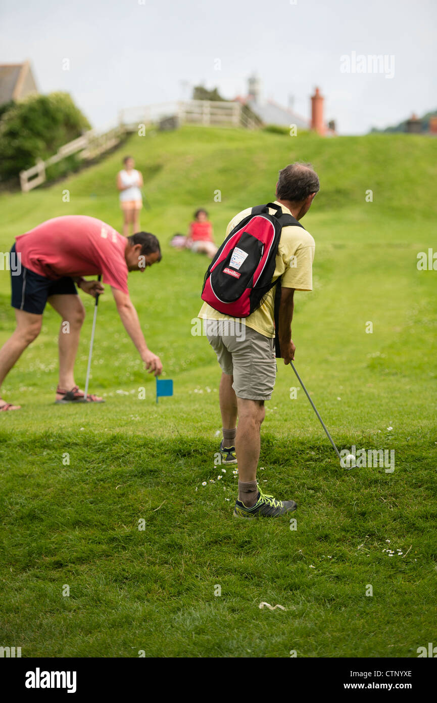 Le persone in vacanza estiva vacanza giocando una partita a mini golf putting Aberystwyth Wales UK Foto Stock