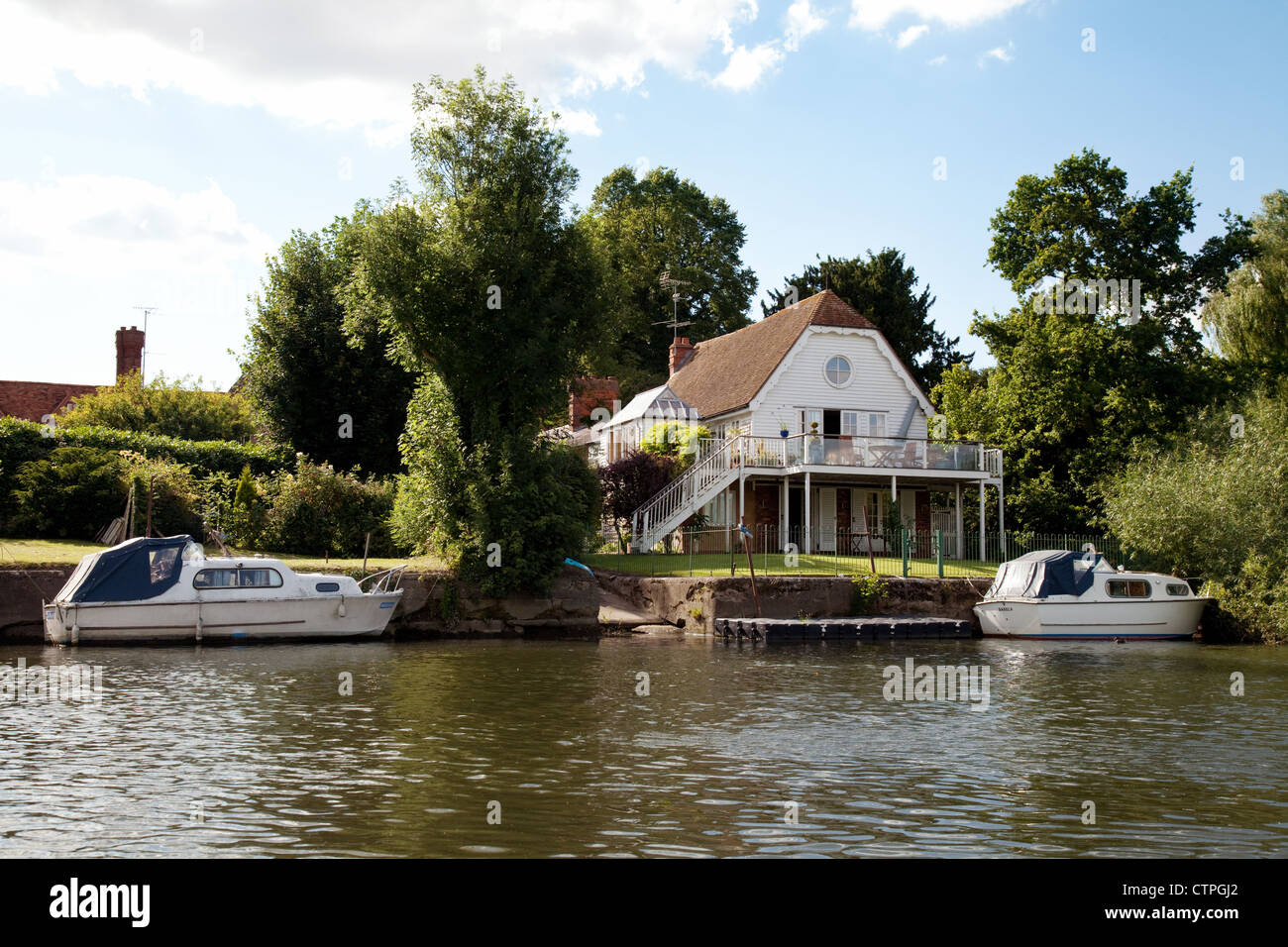 Barche a motore ormeggiata presso una casa sul Fiume Tamigi a Wallingford, Oxfordshire, Regno Unito Foto Stock