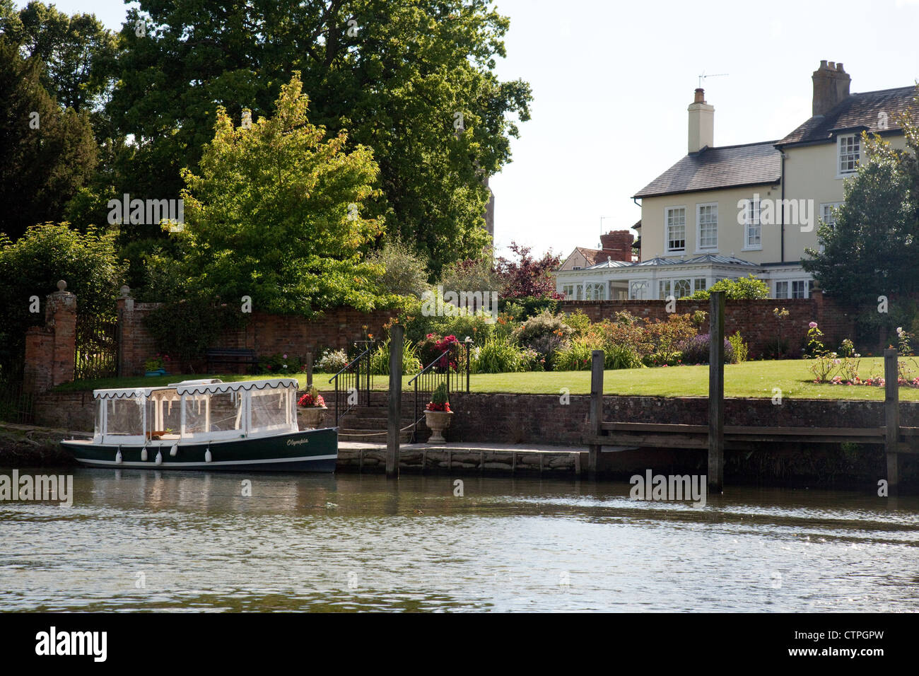 Un elettrico barca ormeggiata presso una casa sul Fiume Tamigi a Wallingford, Oxfordshire, Regno Unito Foto Stock