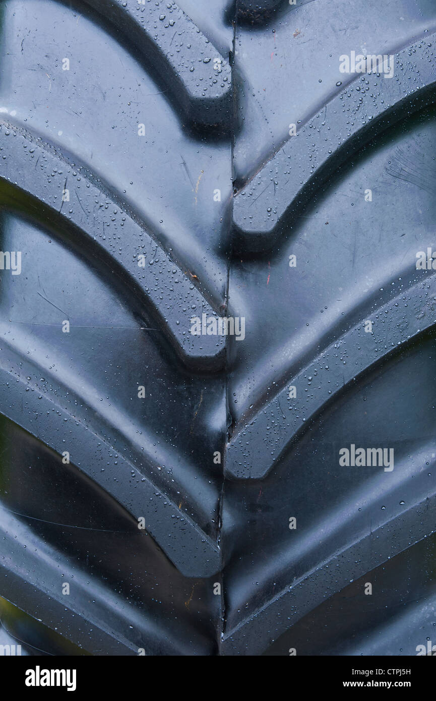 Gocce di acqua piovana cordone sul pneumatico pneumatico di un veicolo agricolo su uno stand in occasione di una mostra Foto Stock
