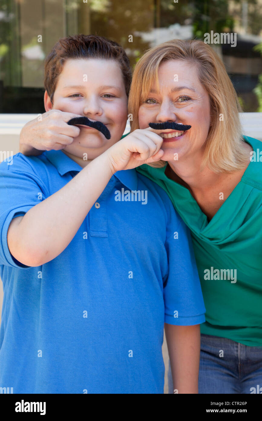 Madre e figlio stanno giocando con fake mustaches. Foto Stock