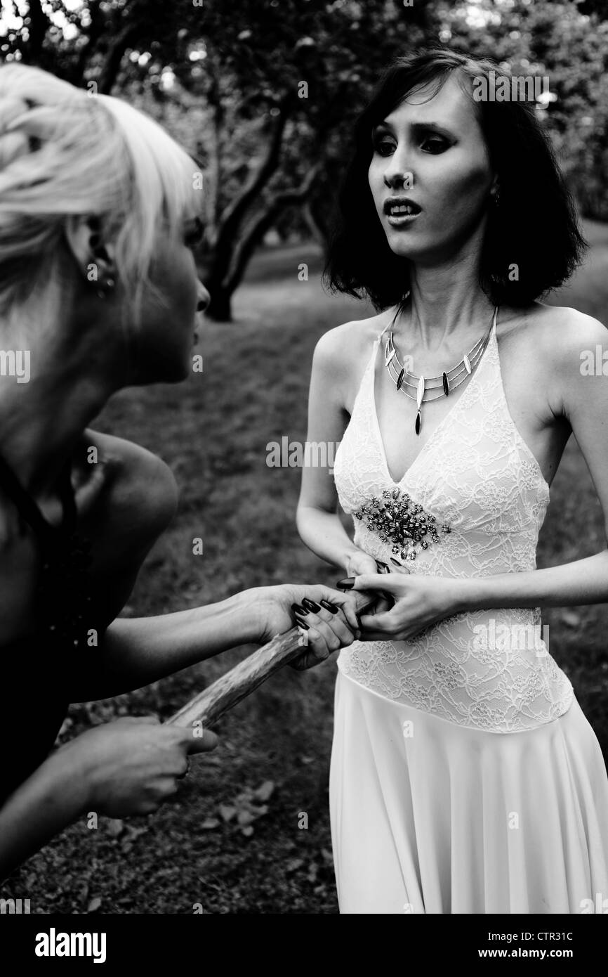 Lotta contro il vampiro: strega e giovane guerriero donna con aspen polo (gioco) al forest Foto Stock