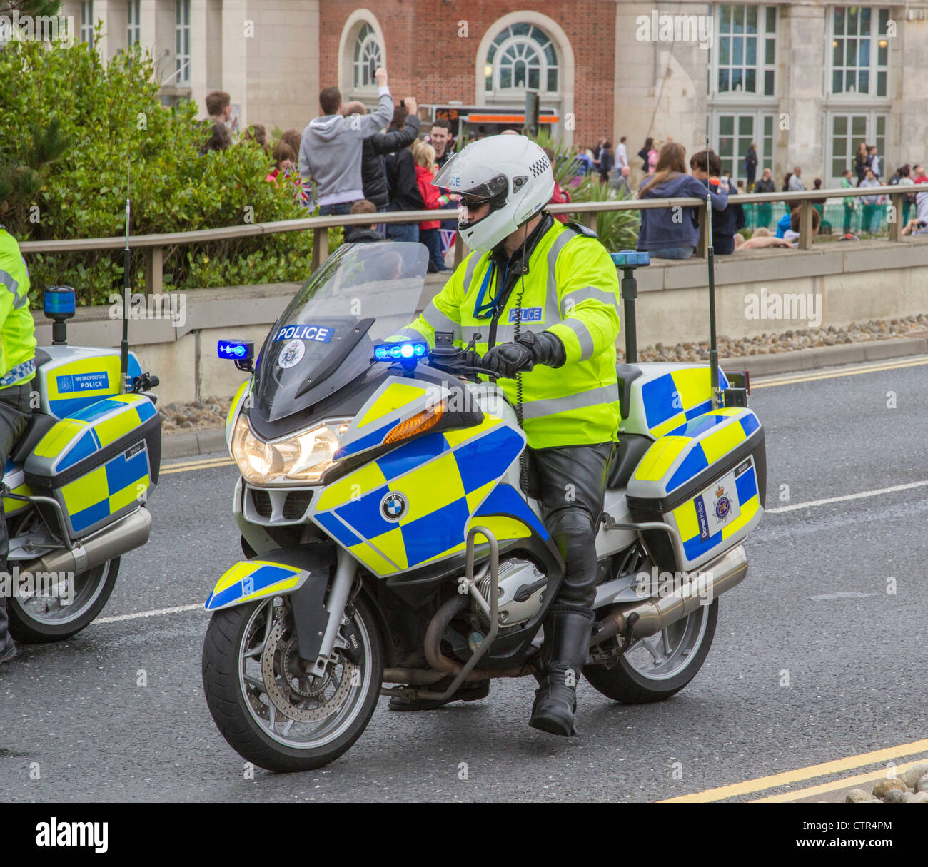 La polizia motociclista a cavallo della sua moto stazionario in carreggiata, Dorset, England, Regno Unito Foto Stock