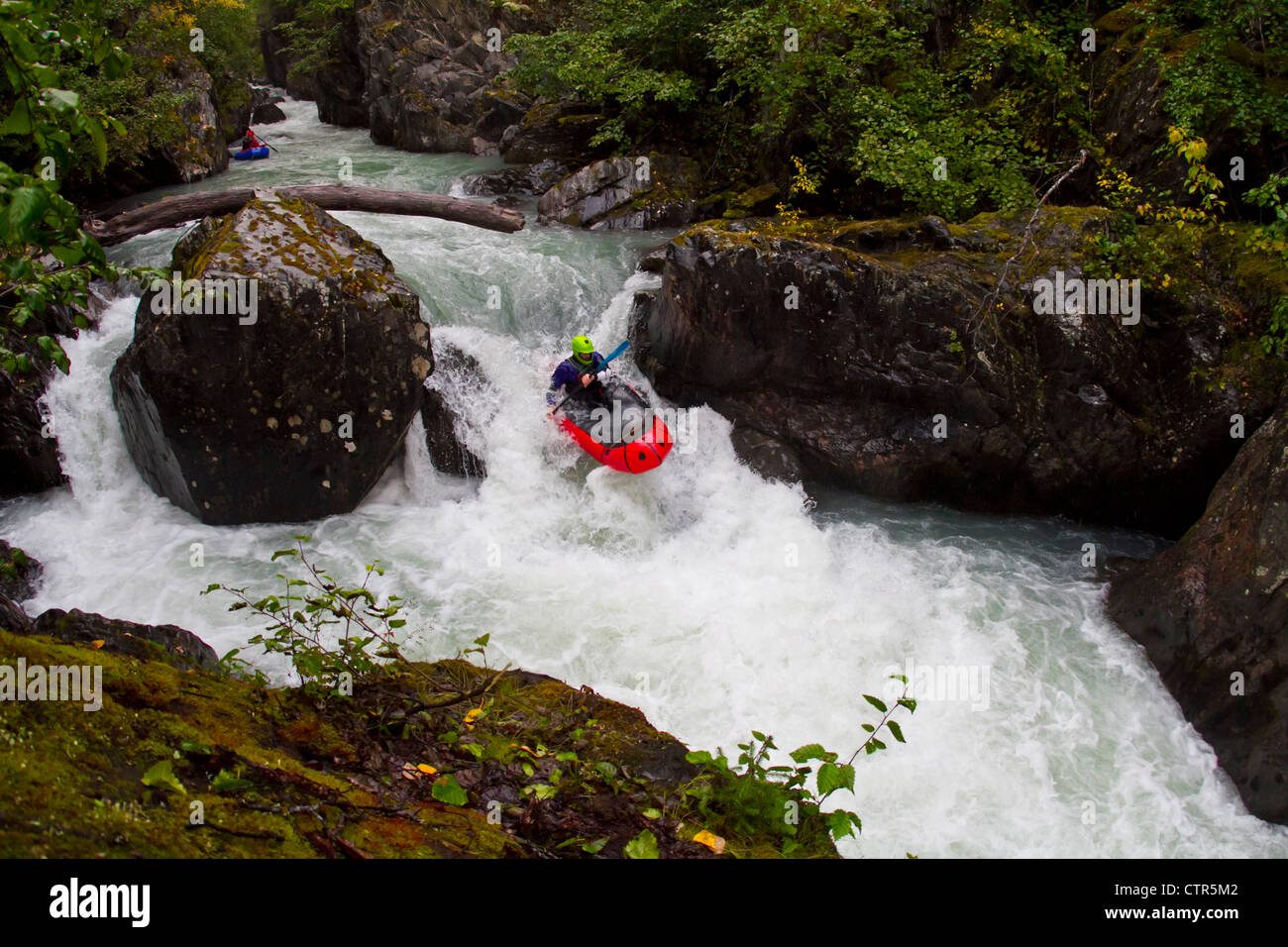 L'uomo packrafting whitewater in Bird Creek, Chugach Mountains, centromeridionale Alaska. Estate Foto Stock