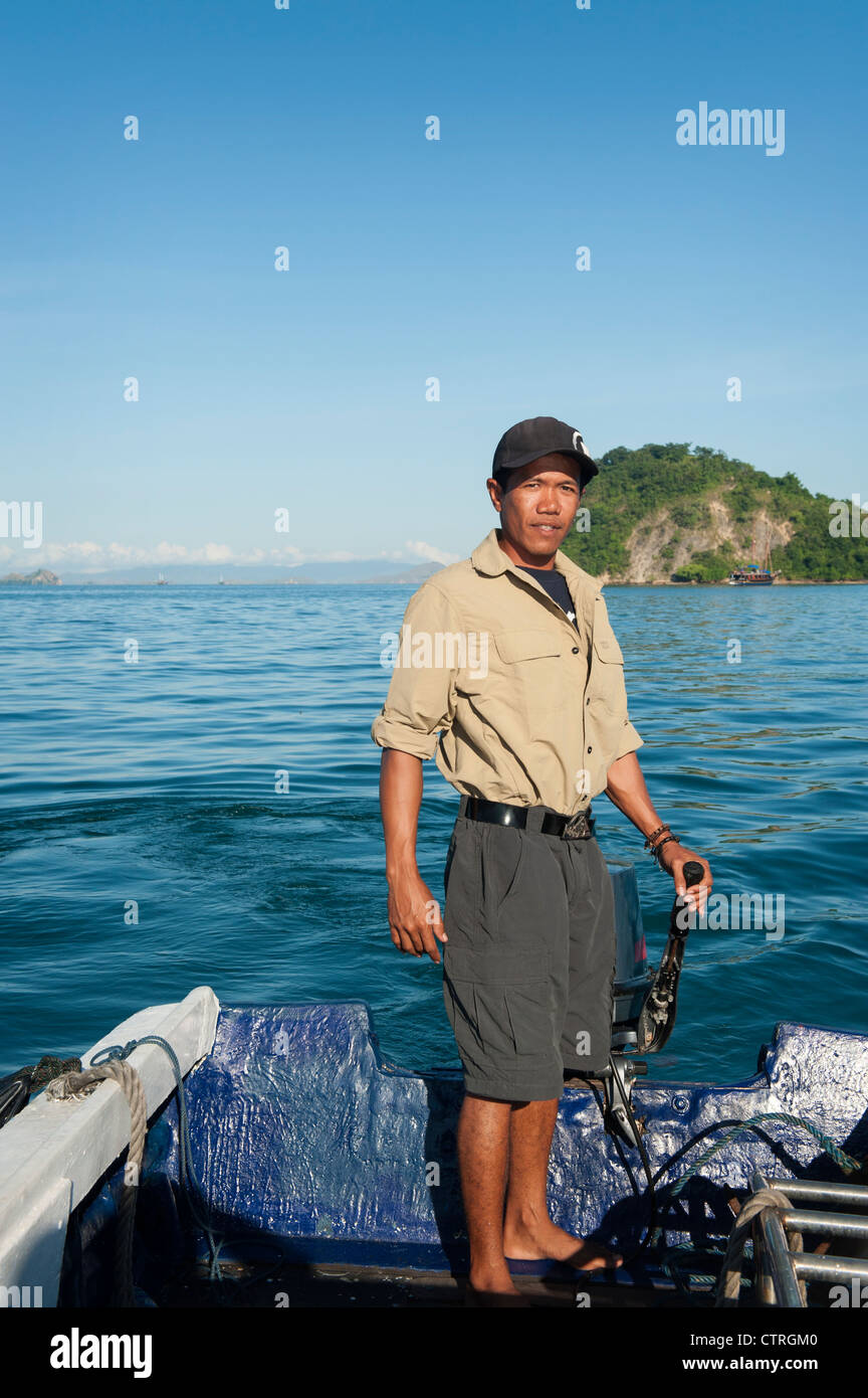 Un membro di equipaggio dall'Ombak Putih, una goletta barca a vela, traghetti passeggeri a riva sull isola di Flores, Indonesia. Foto Stock