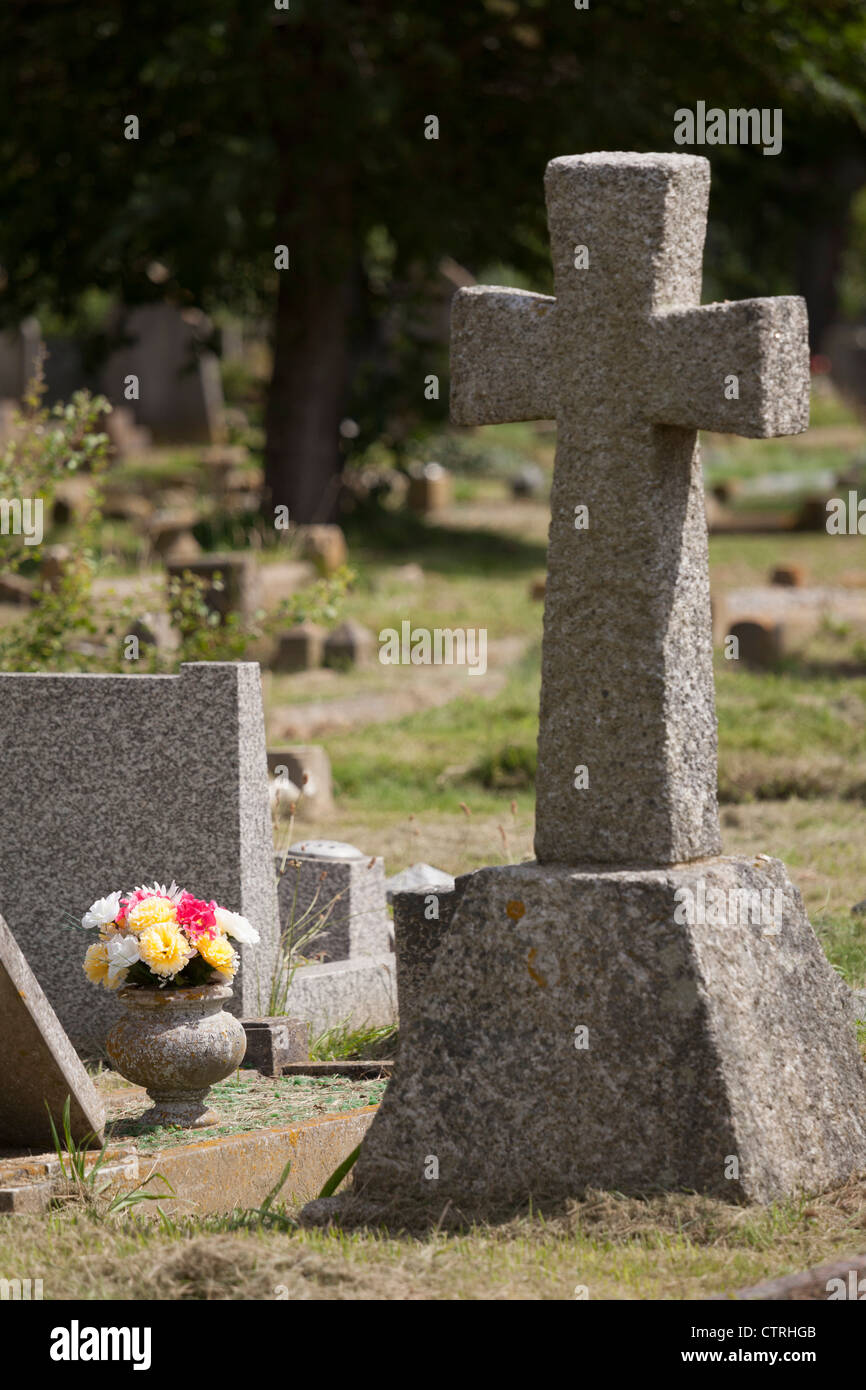Lapidi e fiori in un cimitero Foto Stock