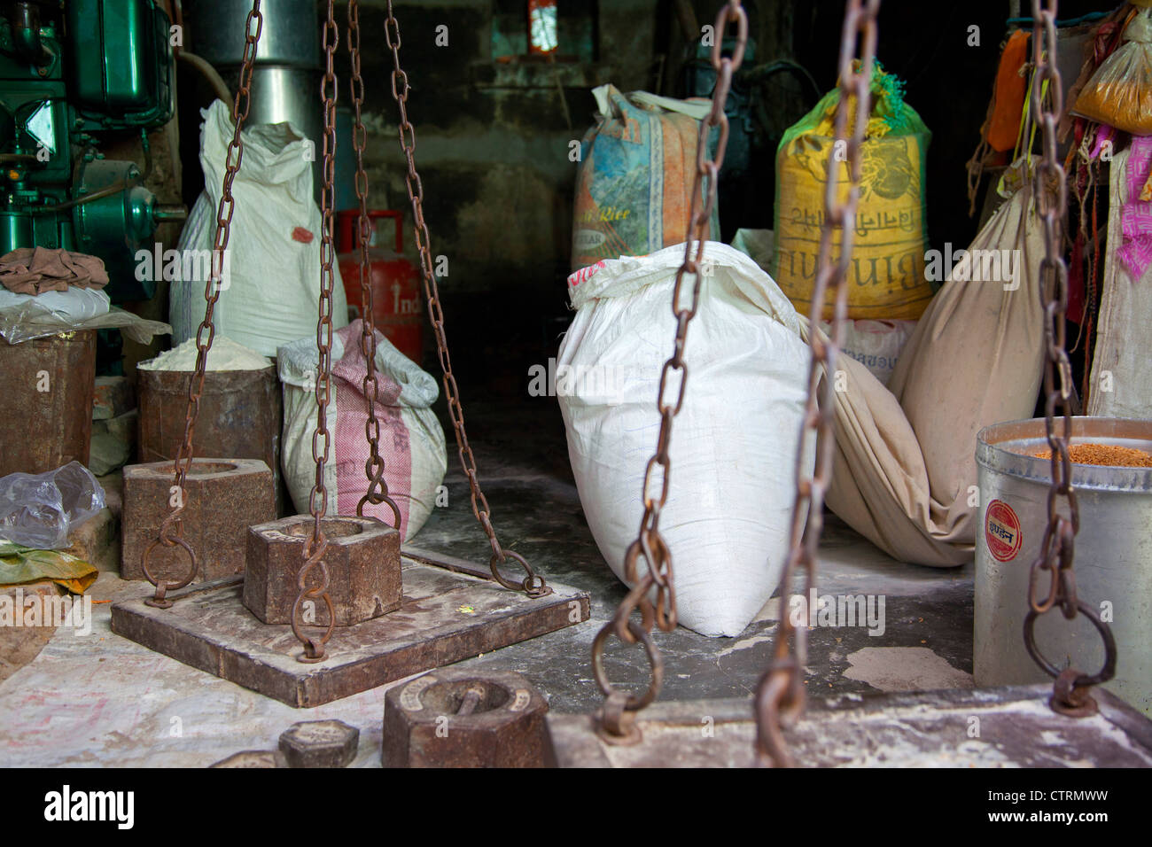Il vecchio equilibrio con pesanti pesi di ferro per la pesatura di sacchi di grano e farina in negozio a Govardhan, Uttar Pradesh, India Foto Stock